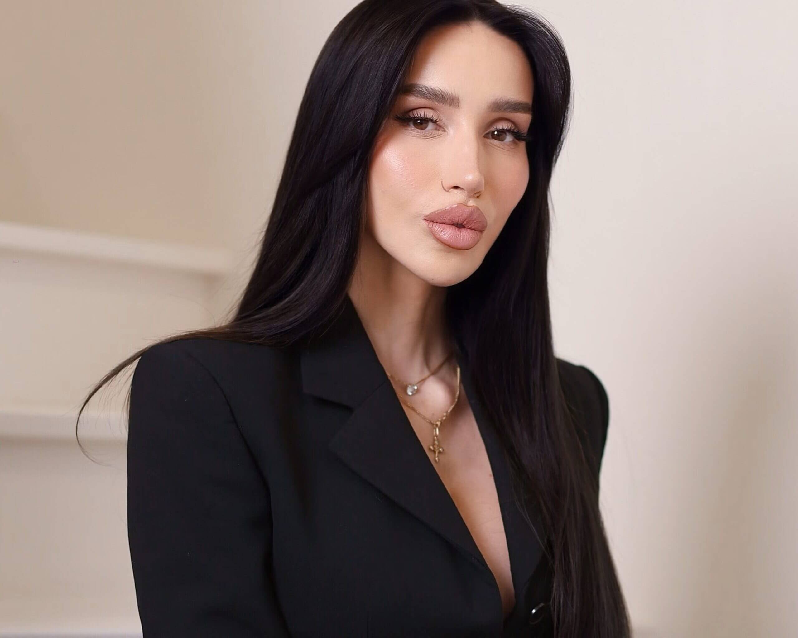 Portrait of Marta Morozova, RN, founder of Aesthetic Nurse Marta, in a black blazer against a light background