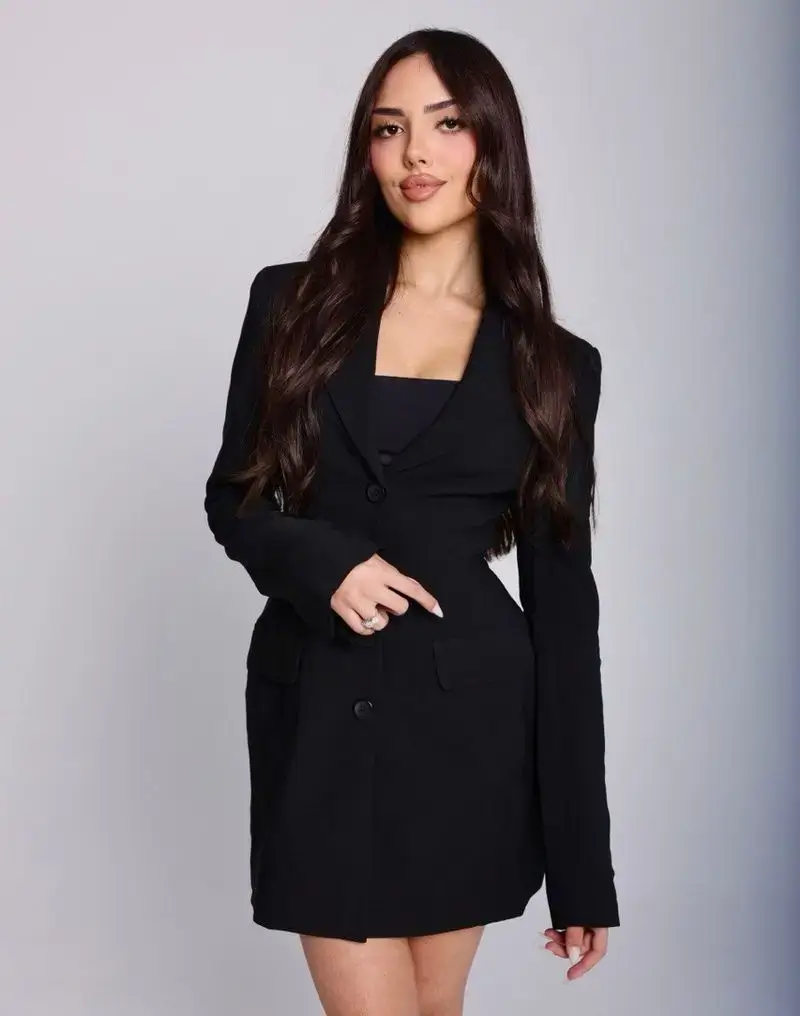 Yasmin Masarat, RN, aesthetic injector at Aesthetic Nurse Marta, standing in a black blazer dress